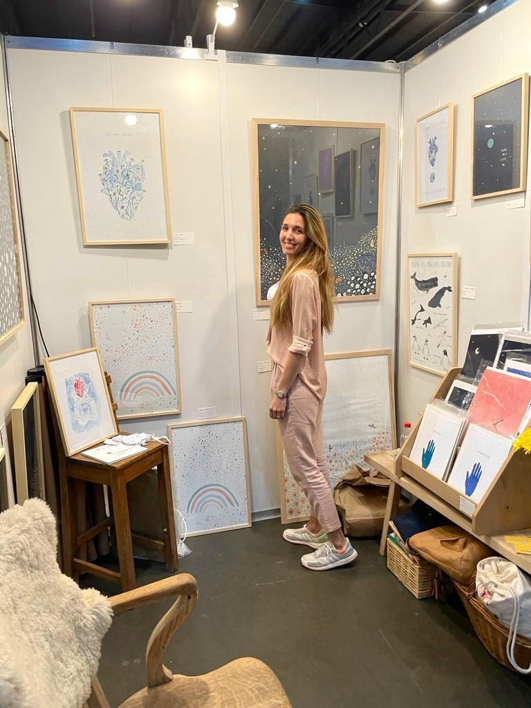 Clara en su stand rodeada de sus láminas